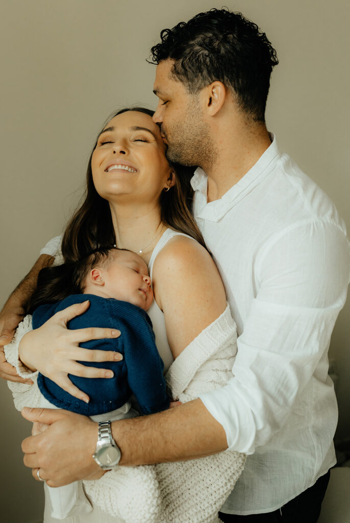 Mother, father, and baby boy during sweet at home newborn photography session in LA