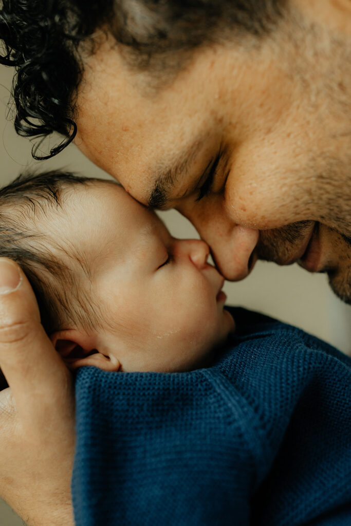 Father touching noses with son