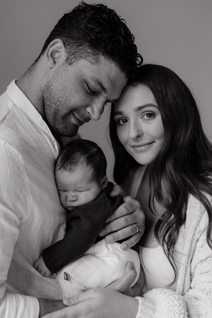 Mother, father, and baby boy during sweet at home newborn photography session in LA