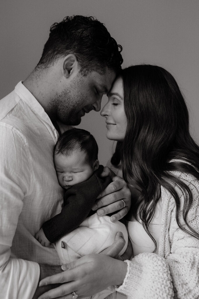 Mother, father, and baby boy during sweet at home newborn photography session in LA
