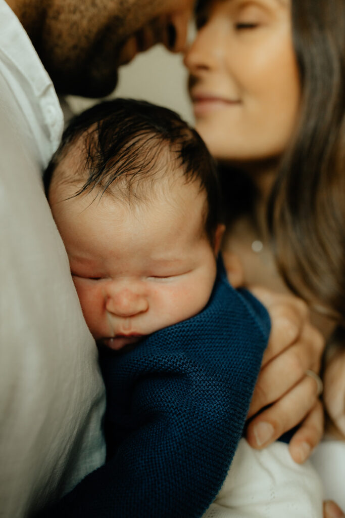 Mother, father, and baby boy during sweet at home newborn photography session in LA