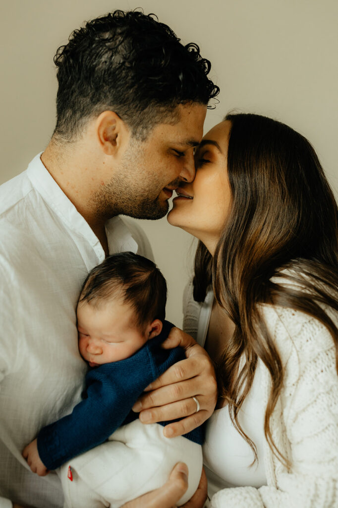 Mother, father, and baby boy during sweet at home newborn photography session in LA