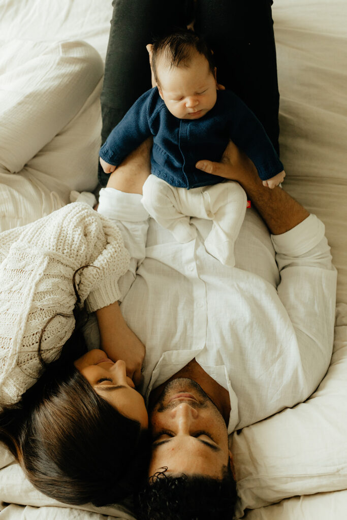 Mother, father, and baby boy during sweet at home newborn photography session in LA