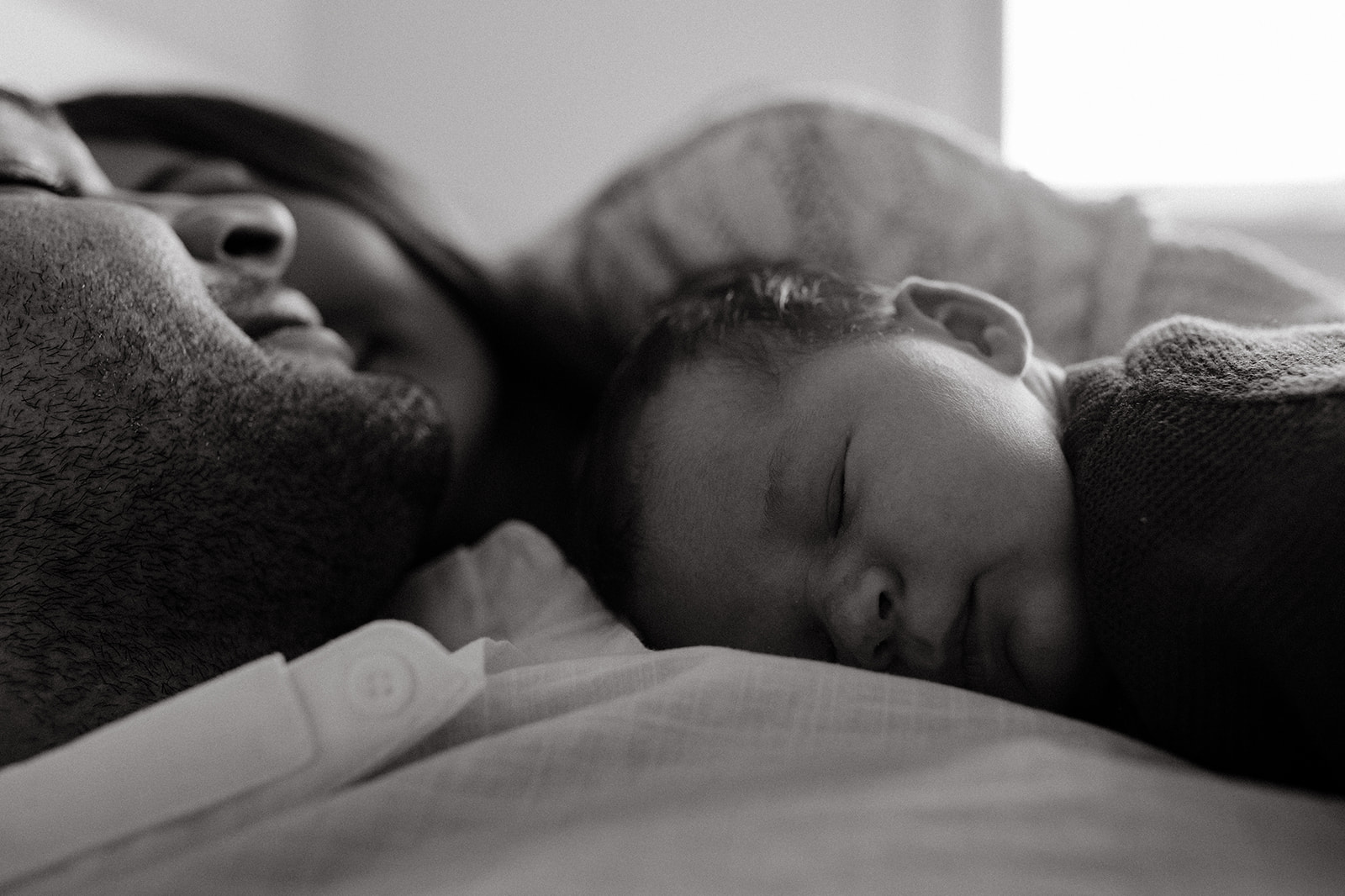 Mother, father, and baby boy during sweet at home newborn photography session in LA