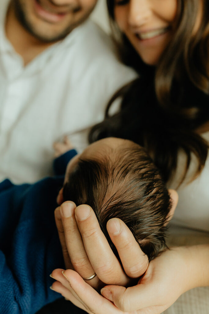 Mother, father, and baby boy during sweet at home newborn photography session in LA