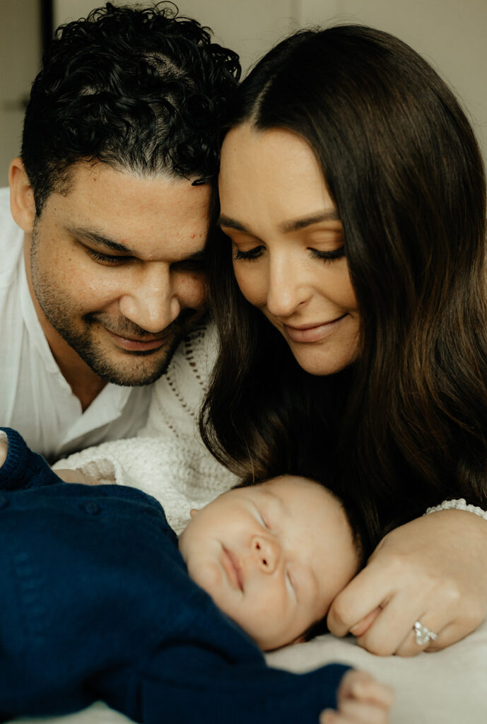 Mother, father, and baby boy during sweet at home newborn photography session in LA