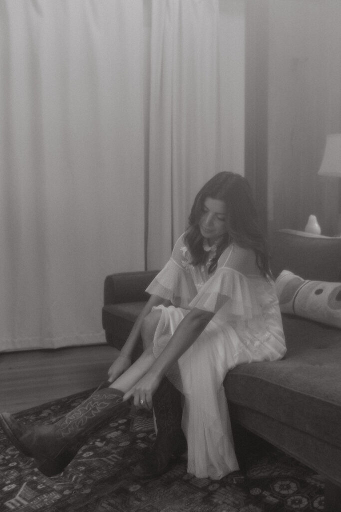 Bride putting western wedding boots on