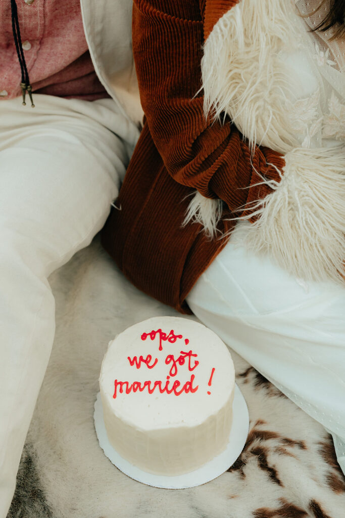 Elopement cake that says "oops, we just got married!"