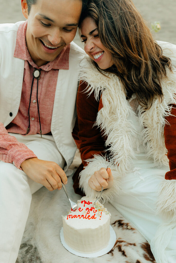 Bride and groom eating elopement cake together