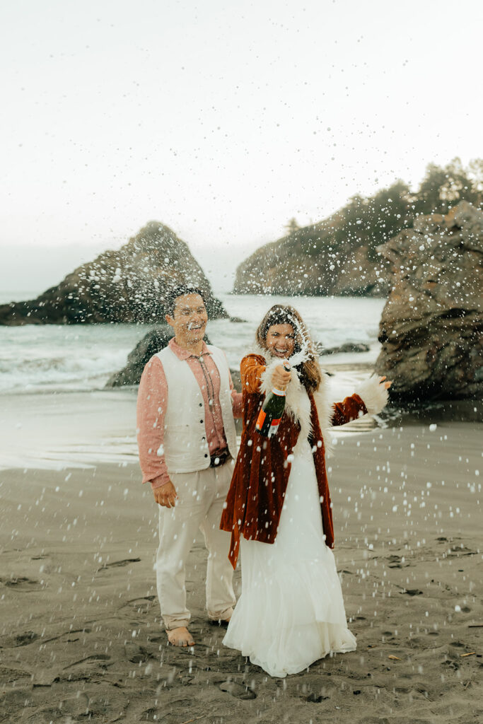 Bride and groom popping champagne
