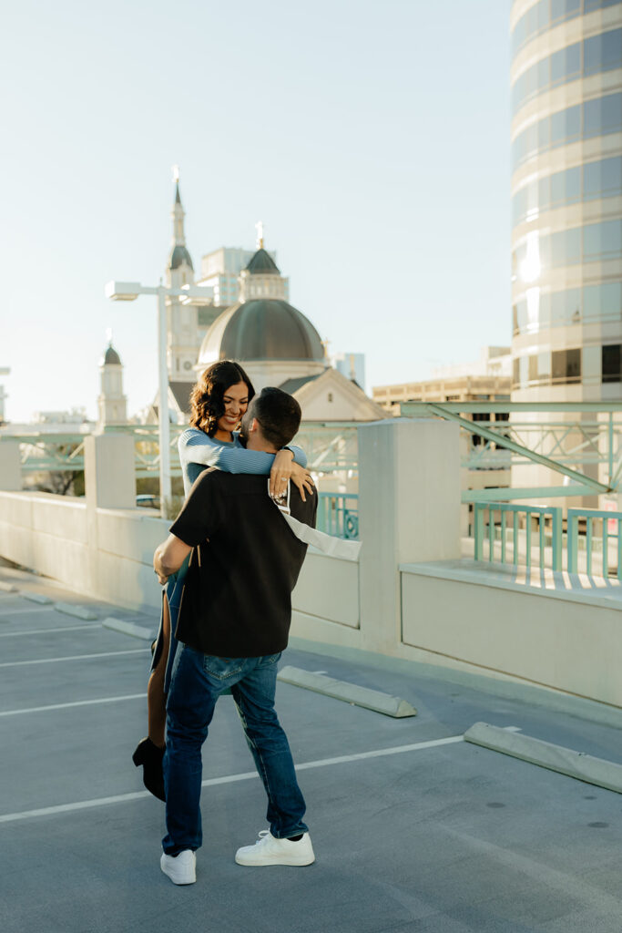 couple playing during their cute rooftop baby announcement