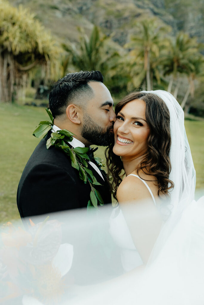 groom kissing the bride on the cheek