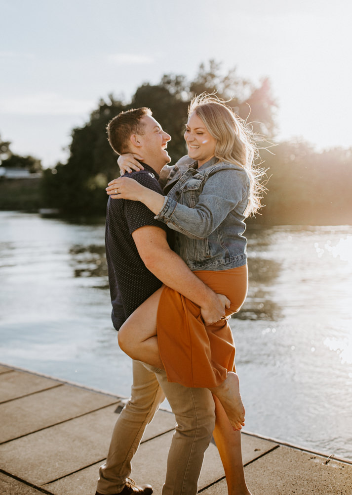 Sacramento River Engagement Session Northern California Weiner dog engagement shoot outfit inspo engagement photos with dog couples shoot posing golden hour sacramento river rachel christopherson photography river lift giggles