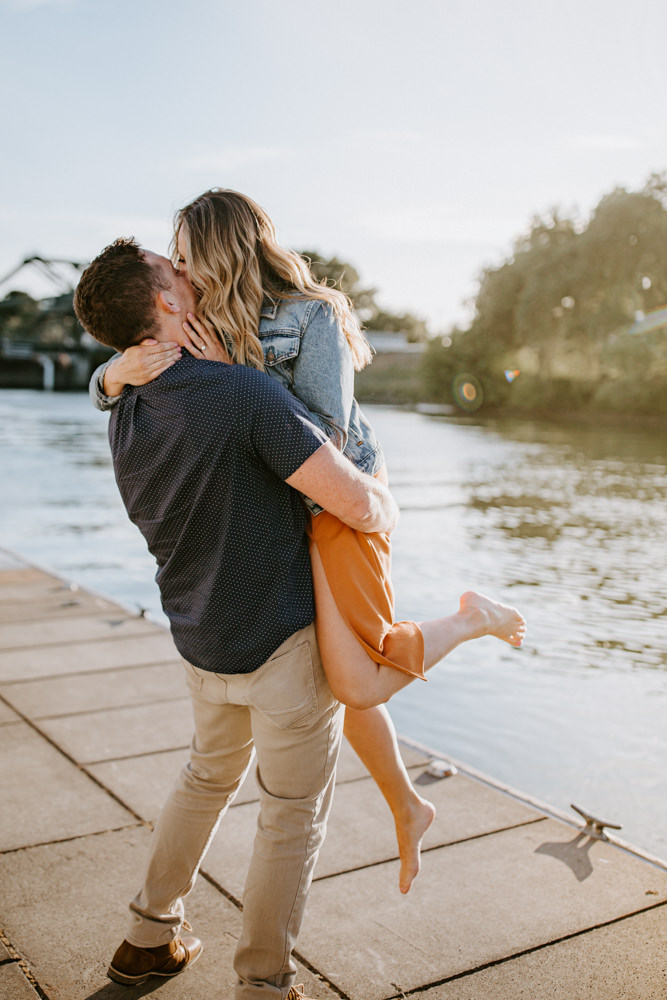 Sacramento River Engagement Session Northern California Weiner dog engagement shoot outfit inspo engagement photos with dog couples shoot posing golden hour sacramento river rachel christopherson photography lift and kiss