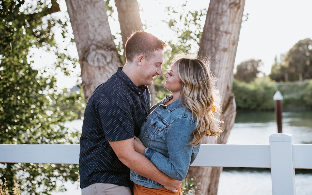 Sacramento River Engagement Session Northern California Weiner dog engagement shoot outfit inspo engagement photos with dog couples shoot posing golden hour sacramento river rachel christopherson photography white fence