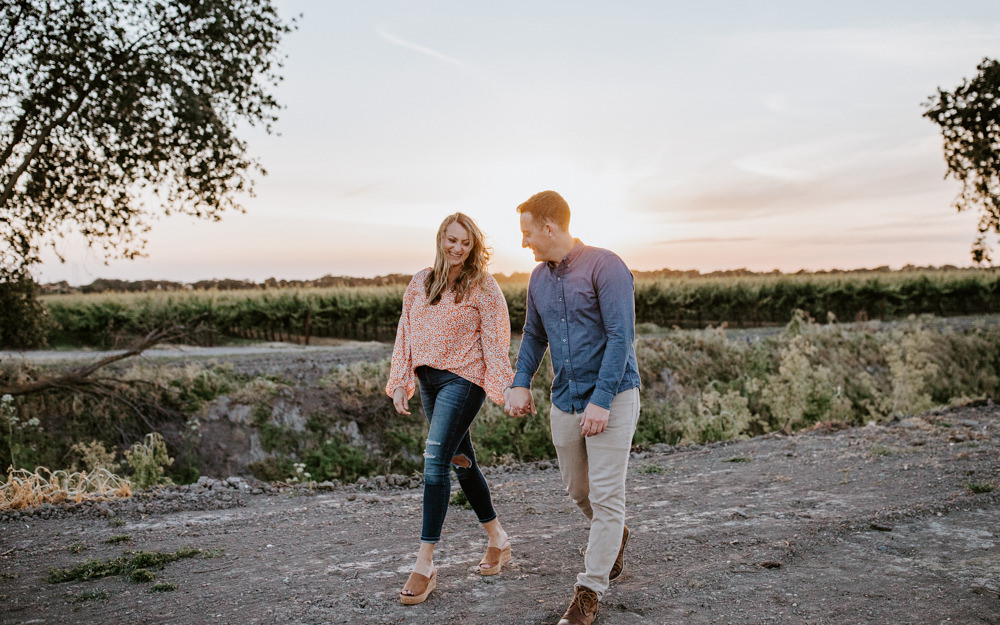 Sacramento River Engagement Session Northern California Weiner dog engagement shoot outfit inspo engagement photos with dog couples shoot posing golden hour sacramento river rachel christopherson photography sunset walking and laugh