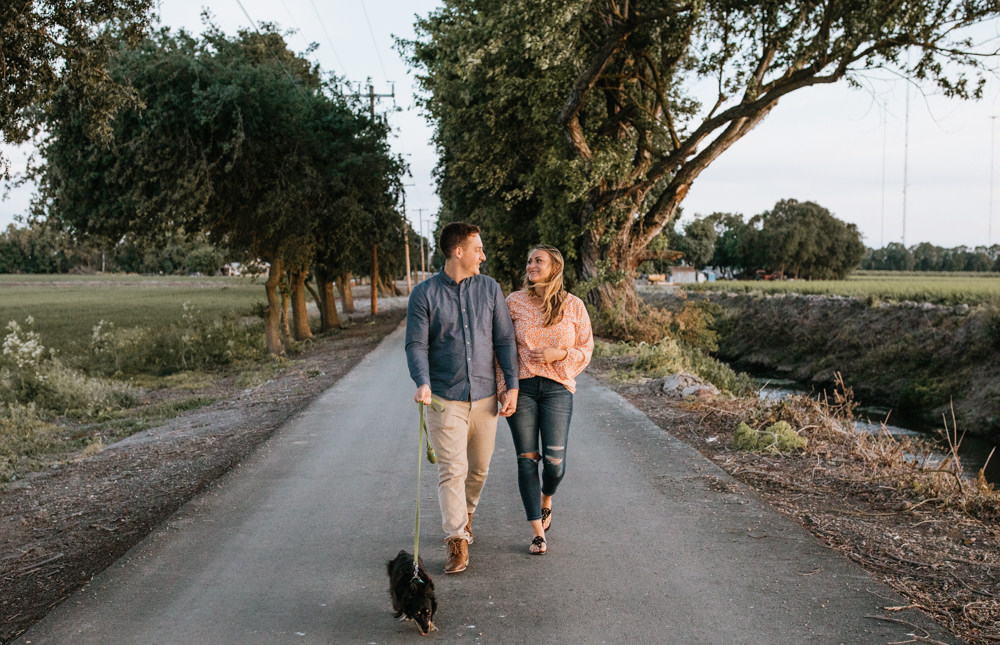 Sacramento River Engagement Session Northern California Weiner dog engagement shoot outfit inspo engagement photos with dog couples shoot posing golden hour sacramento river rachel christopherson photography walking dog on street