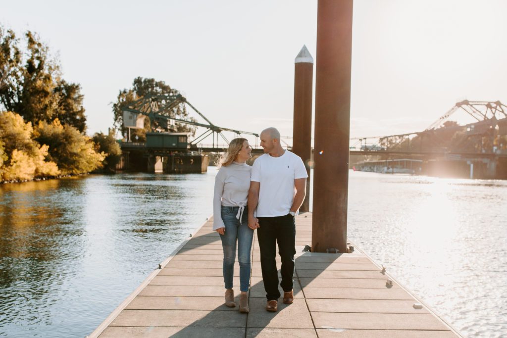 couple walking on doc over river, Sacramento engagement photos, sacramento engagement, sacramento engagement photographer sacramento engagement photo locations, sacramento wedding photographer, rachel christopherson photography, engagement photo outfit inspo