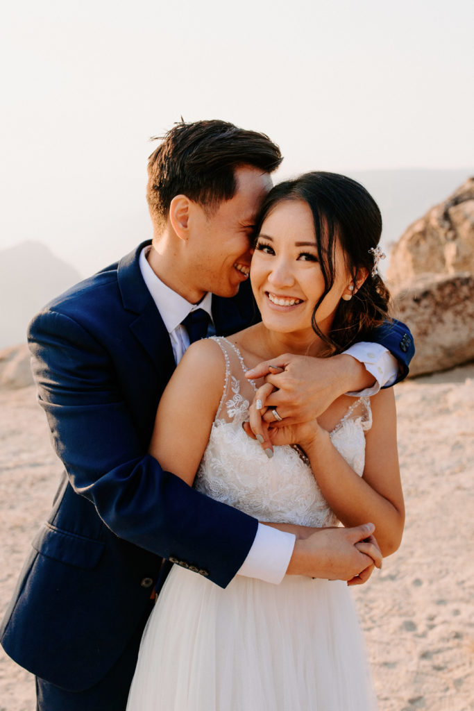 photo of groom arms wrapped around bride from behind, Taft Point elopement, Yosemite Elopement, Glacier Point Elopement, best places to elope in california, northern california elopement, Rachel Christopherson Photography