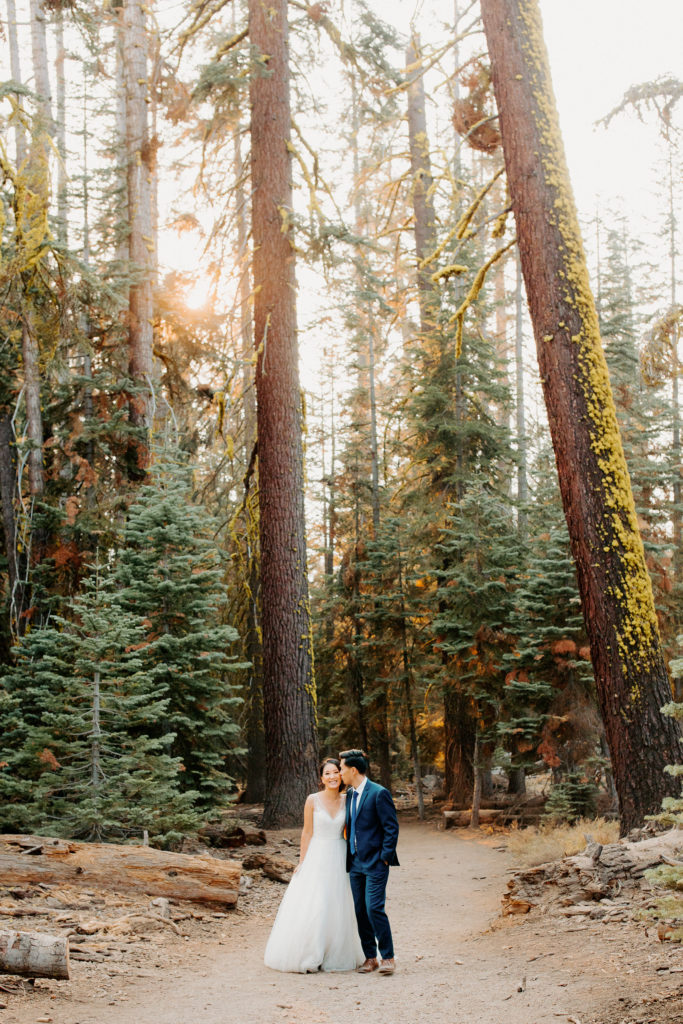 bride and groom walk in forest, adventurous bride, wedding dress and hiking boots, Taft Point elopement, Yosemite Elopement, Glacier Point Elopement, best places to elope in california, northern california elopement, Rachel Christopherson Photography