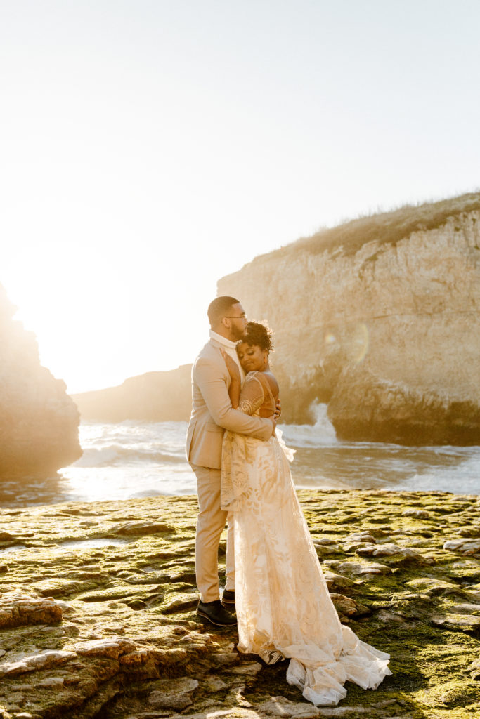 bride hugging groom at beach sunset, Santa cruz wedding, santa cruz elopement, santa cruz wedding photographer, santa cruz elopement photographer, big sur elopement, boho beach bride, california boho elopement, boho wedding dress, best places to elope in California, California elopement, California beach elopement, boho bride inspo, Rachel Christopherson Photography