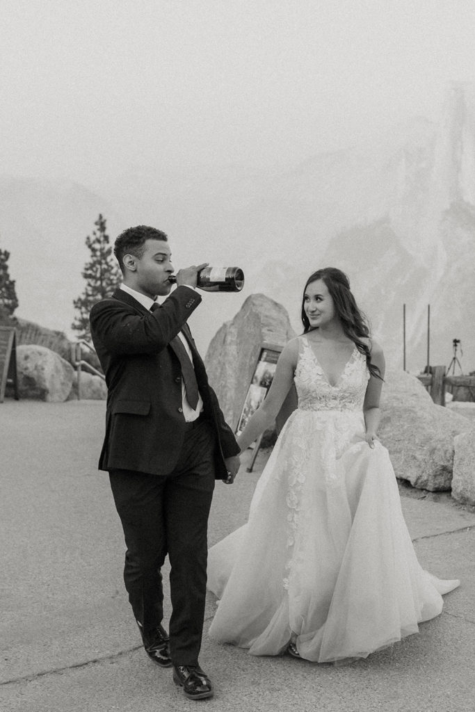 rachelchristophersonphotos-glacier point yosemite elopement-yosemite elopement-glacier point elopement-mountain top elopement-northern california elopement-bride and groom-slick black suit-lacey floral wedding gown-black and white wedding photos-champagne pop-champagne pop photos