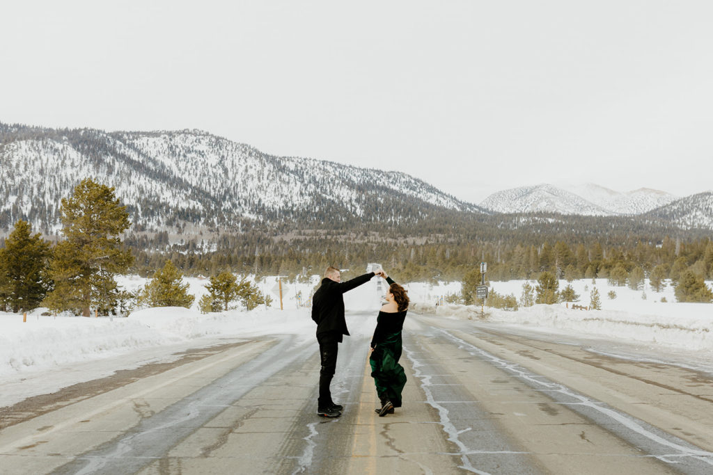 Rachel Christopherson Photography - Northern california winter engagement photos, man twirling fiance in middle of road in front of snowy mountain