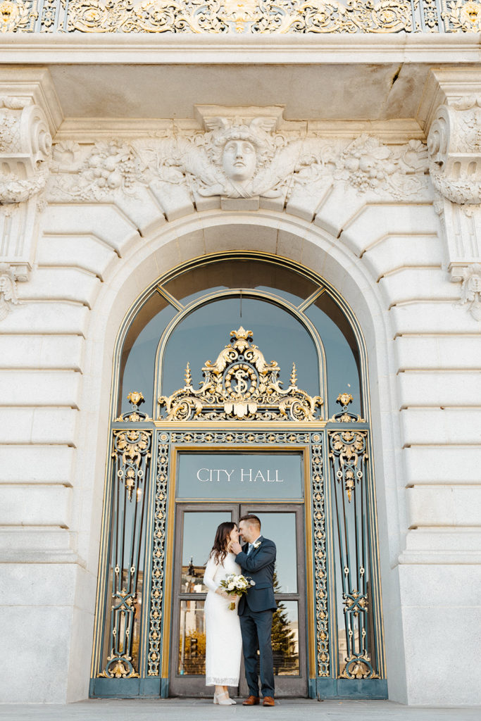 Rachel Christopherson Photographer-SF, San Francisco city hall elopement, san francisco wedding, bride and groom just married, in front of SF city hall ornate doors, ivory wedding dress, gray grooms suit