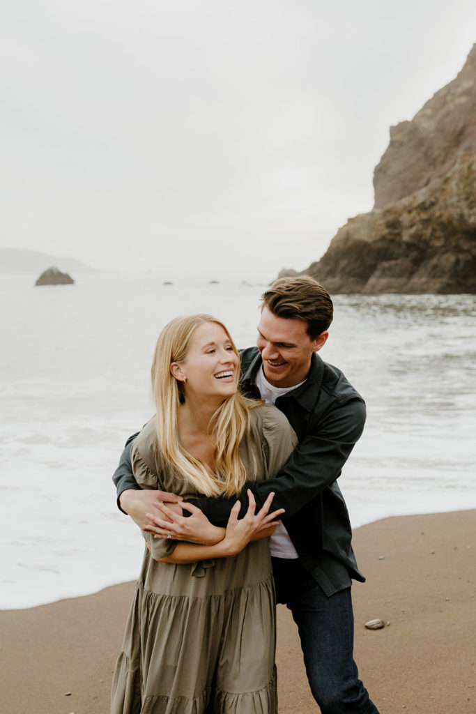 Rachel Christopherson Photography - Engaged couple holding each other on northern california beach , kirby cove engagement photos