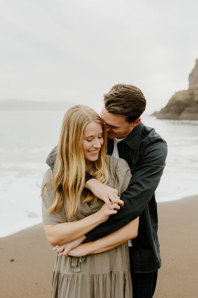 Rachel Christopherson Photography - Engaged couple holding each other on northern california beach , kirby cove engagement photos, beach engagement