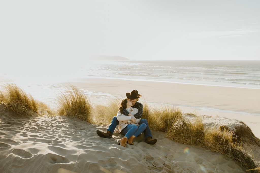 Rachel Christopherson Engagement Photographer-Engaged couple cuddling and smiling at each other on beach-San Francisco Engagement Photos, Northern California Engagement Photos, Point Reyes Engagement Photos, Bodega Bay Engagement Photos, Dillon Beach Engagement Photos, Bay Area Engagement Photos