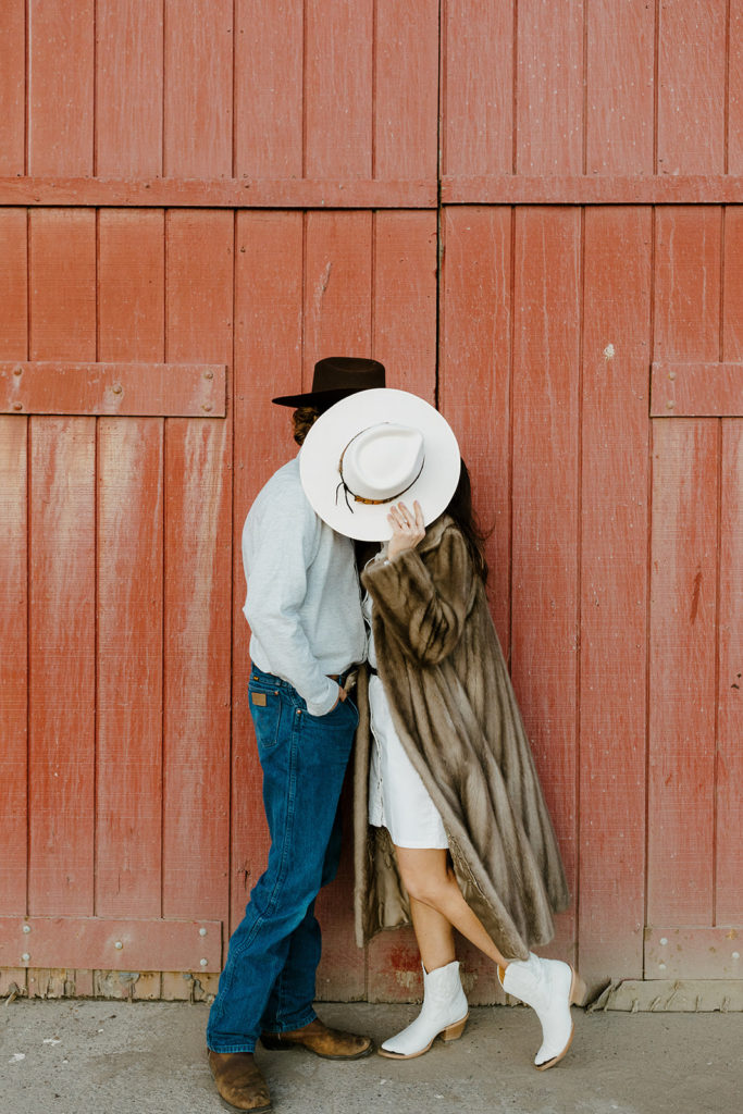 Rachel Christopherson Engagement Photographer-Engaged couple kissing behind cowboy hat-San Francisco Engagement Photos, Northern California Engagement Photos, Point Reyes Engagement Photos, Bodega Bay Engagement Photos, Dillon Beach Engagement Photos, Bay Area Engagement Photos