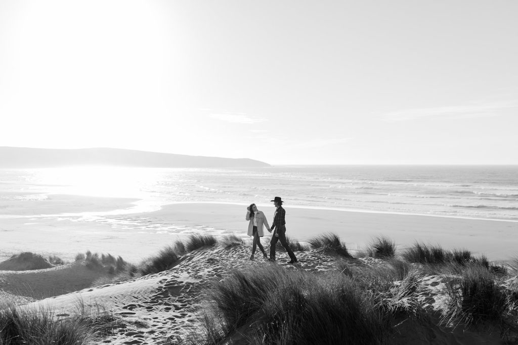 Rachel Christopherson Engagement Photographer-Engaged couple holding hands and walking on beach, black and white engagement photos-San Francisco Engagement Photos, Northern California Engagement Photos, Point Reyes Engagement Photos, Bodega Bay Engagement Photos, Dillon Beach Engagement Photos, Bay Area Engagement Photos