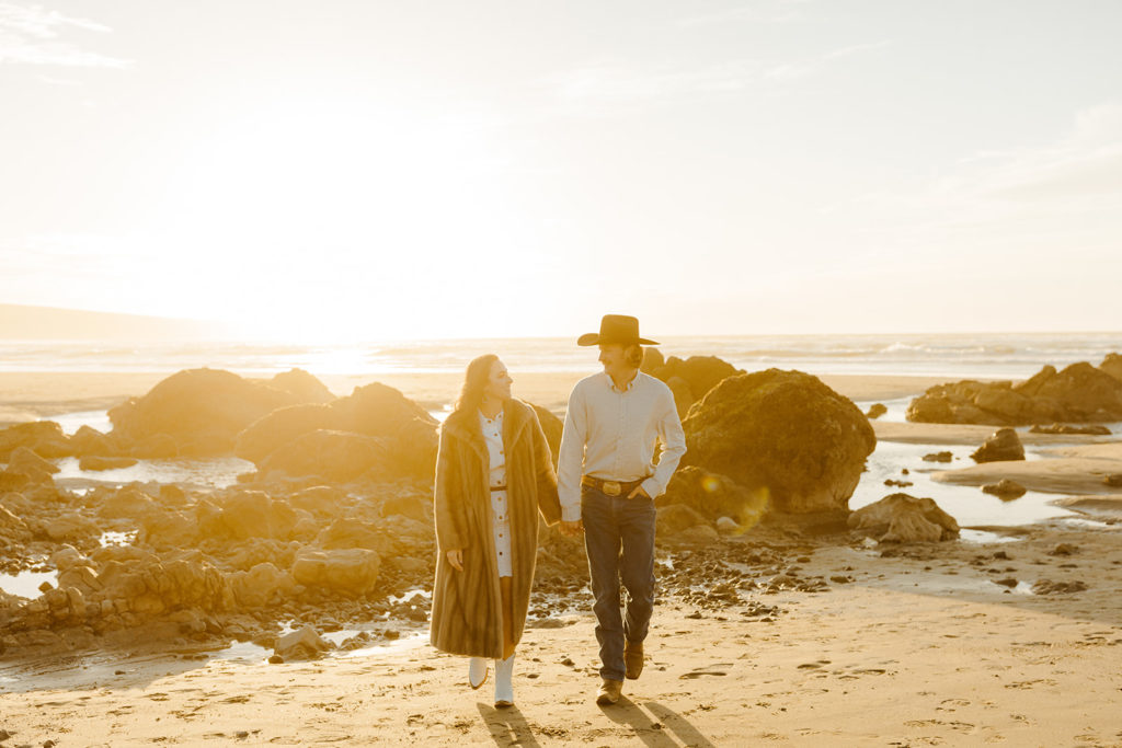 Rachel Christopherson Engagement Photographer-Engaged couple holding hands and smiling at each other on beach-San Francisco Engagement Photos, Northern California Engagement Photos, Point Reyes Engagement Photos, Bodega Bay Engagement Photos, Dillon Beach Engagement Photos, Bay Area Engagement Photos