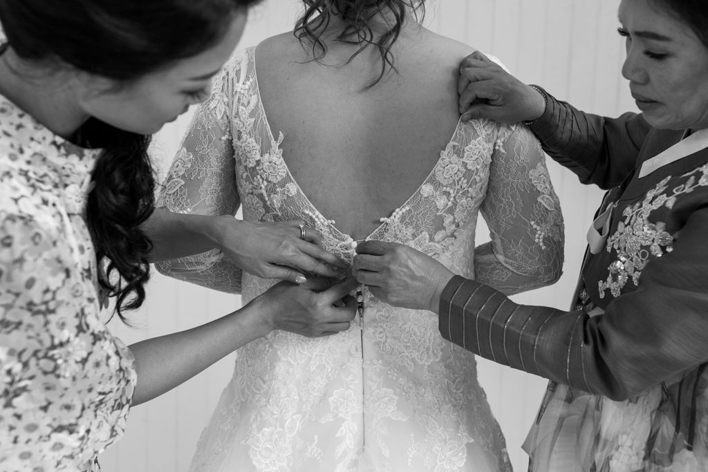 Rachel Christopherson Photography - North Shore Oahu wedding at Sunset Ranch, bride getting ready photos, bride putting dress on, black and white wedding photos 