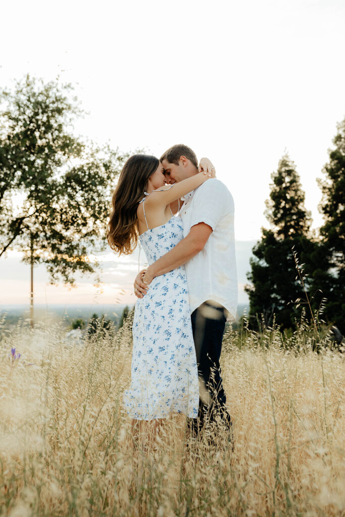 Couple posing for romantic field engagement photos in Auburn, California