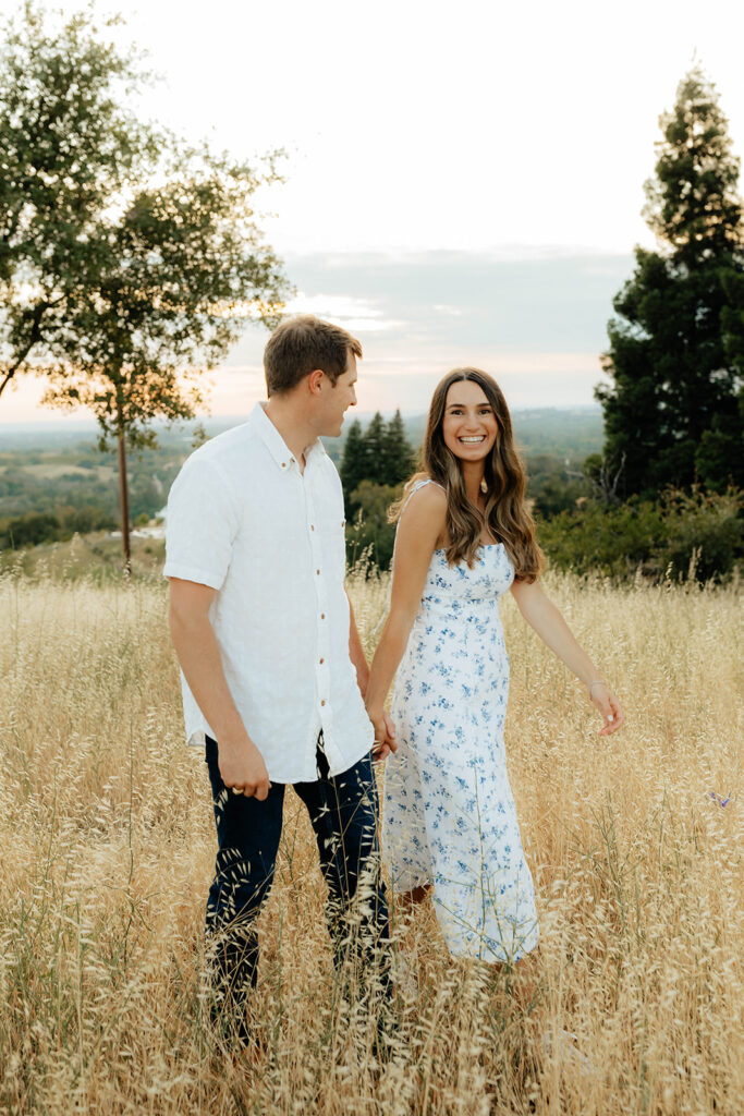 Couple posing for romantic field engagement photos in Auburn, California