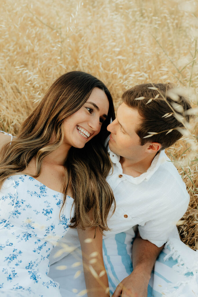 Couple posing for romantic field engagement photos in Auburn, California