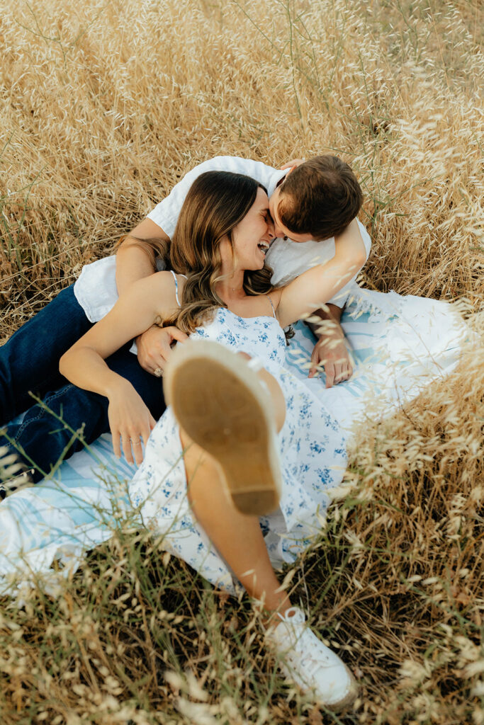 Couple posing for romantic field engagement photos in Auburn, California