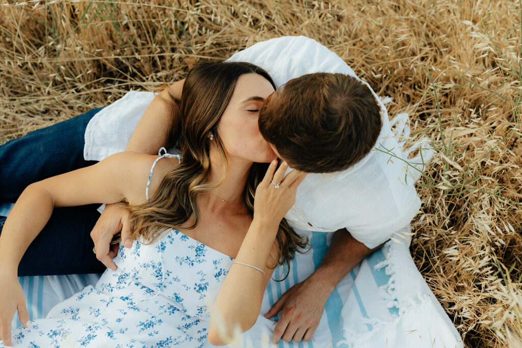 Couple posing for romantic field engagement photos in Auburn, California