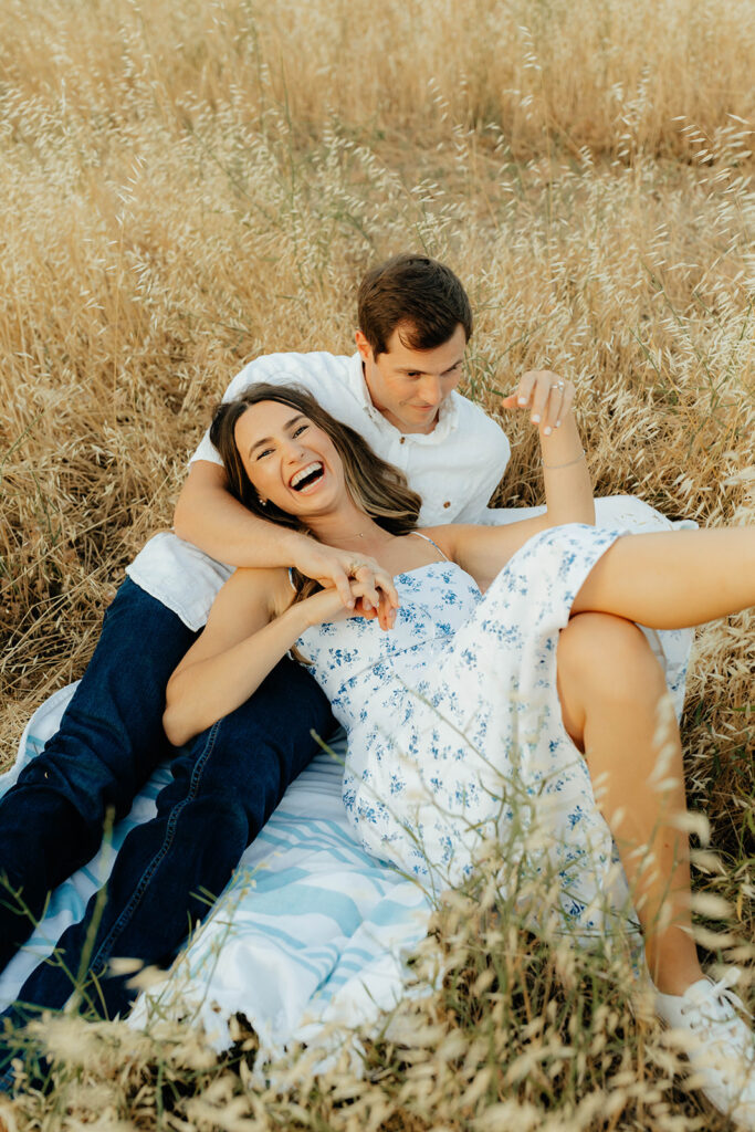 Couple posing for romantic field engagement photos in Auburn, California