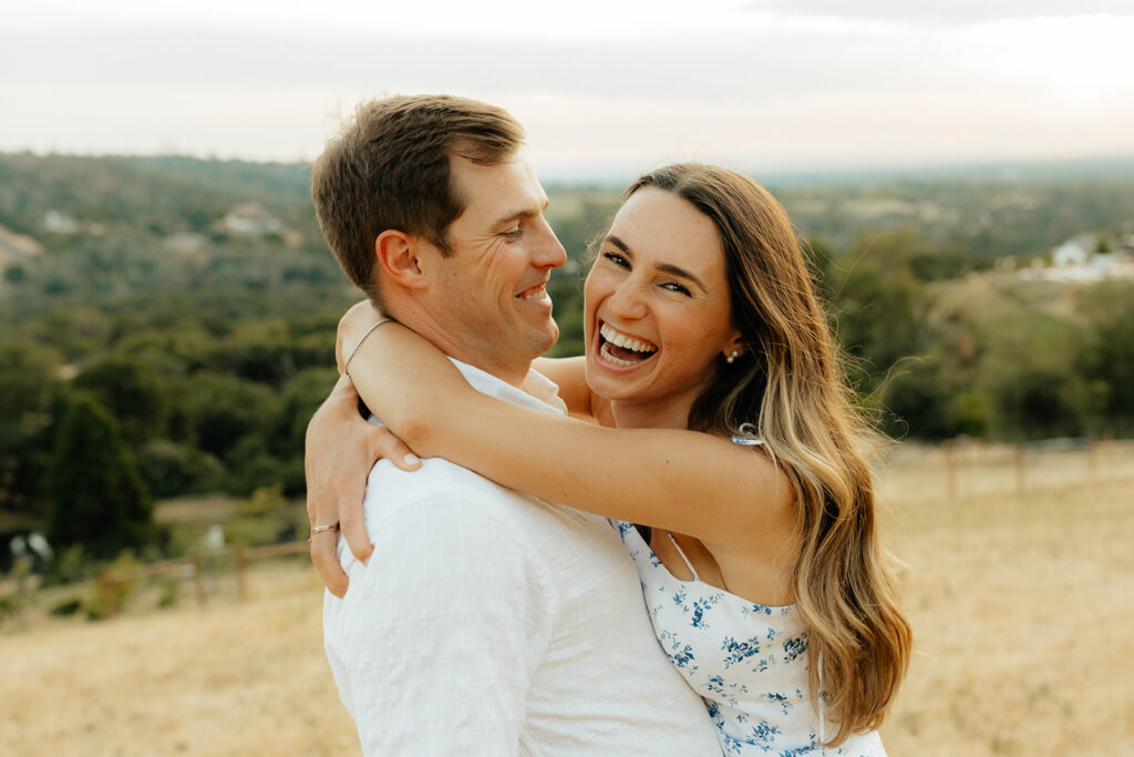 Couple posing for romantic field engagement photos in Auburn, California