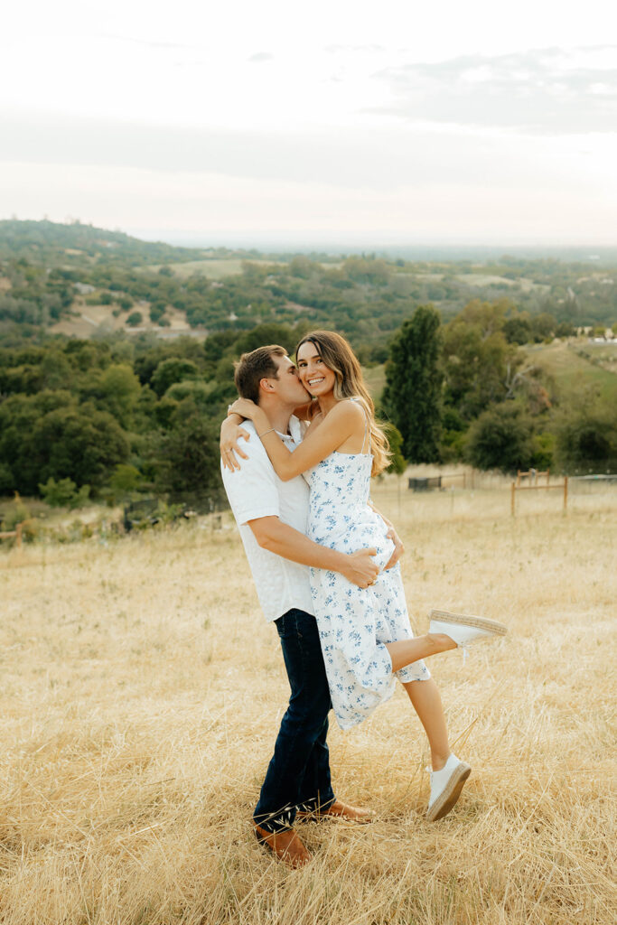 Couple posing for romantic field engagement photos in Auburn, California