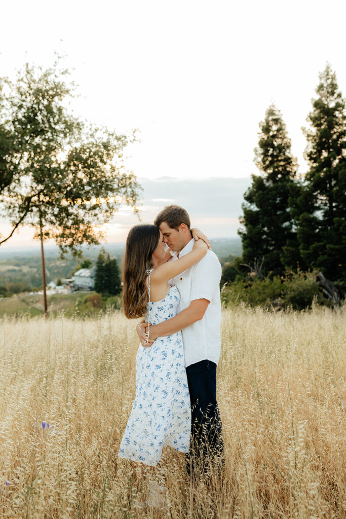 Couple posing for romantic field engagement photos in Auburn, California