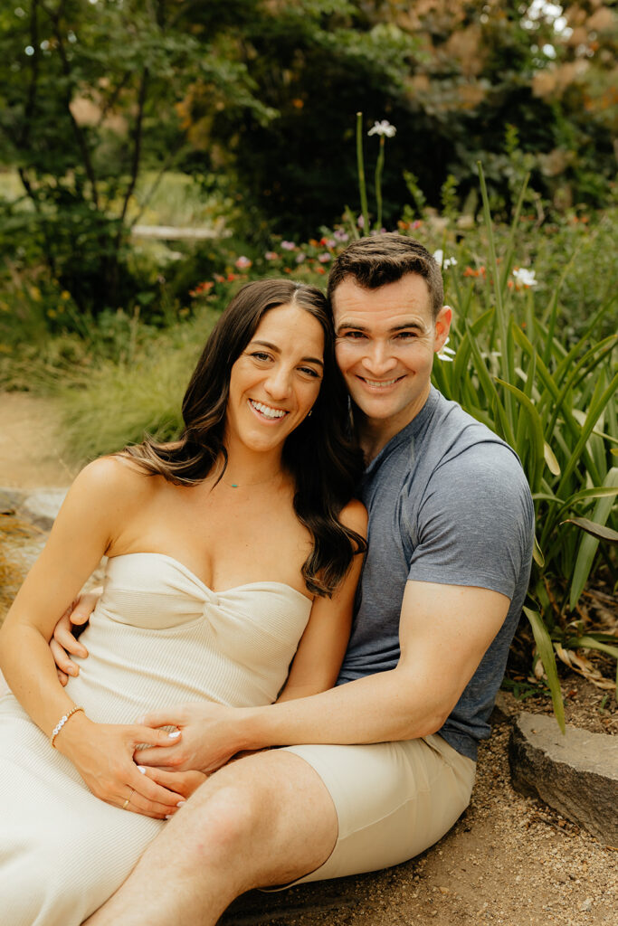 Couple sitting on the ground for maternity photoshoot
