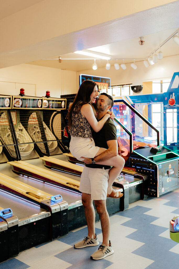 Couple playing skee ball at an arcade