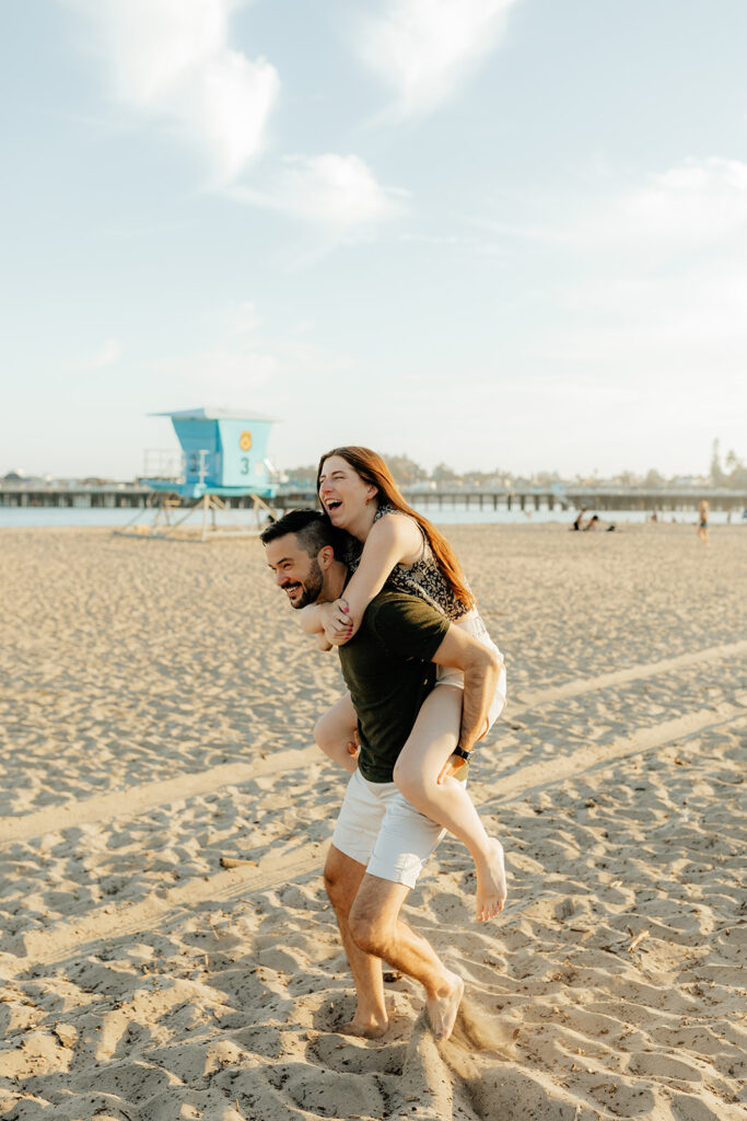 Couple running on the beach for Santa Cruz Beach engagement photos