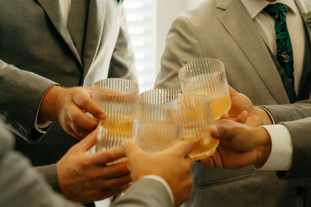 Groom and groomsmen toasting drinks before ceremony