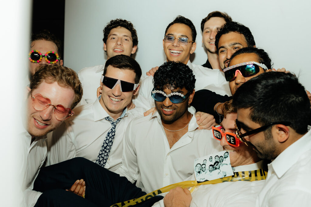 Groom and groomsmen taking photobooth pictures