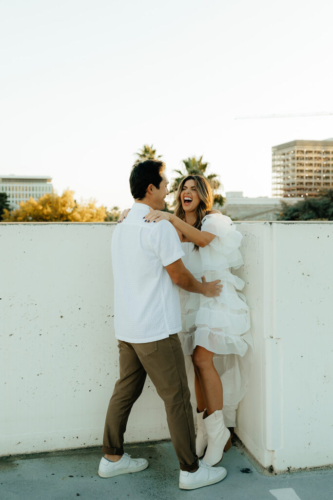 Playful couples rooftop downtown engagement photos in Sacramento